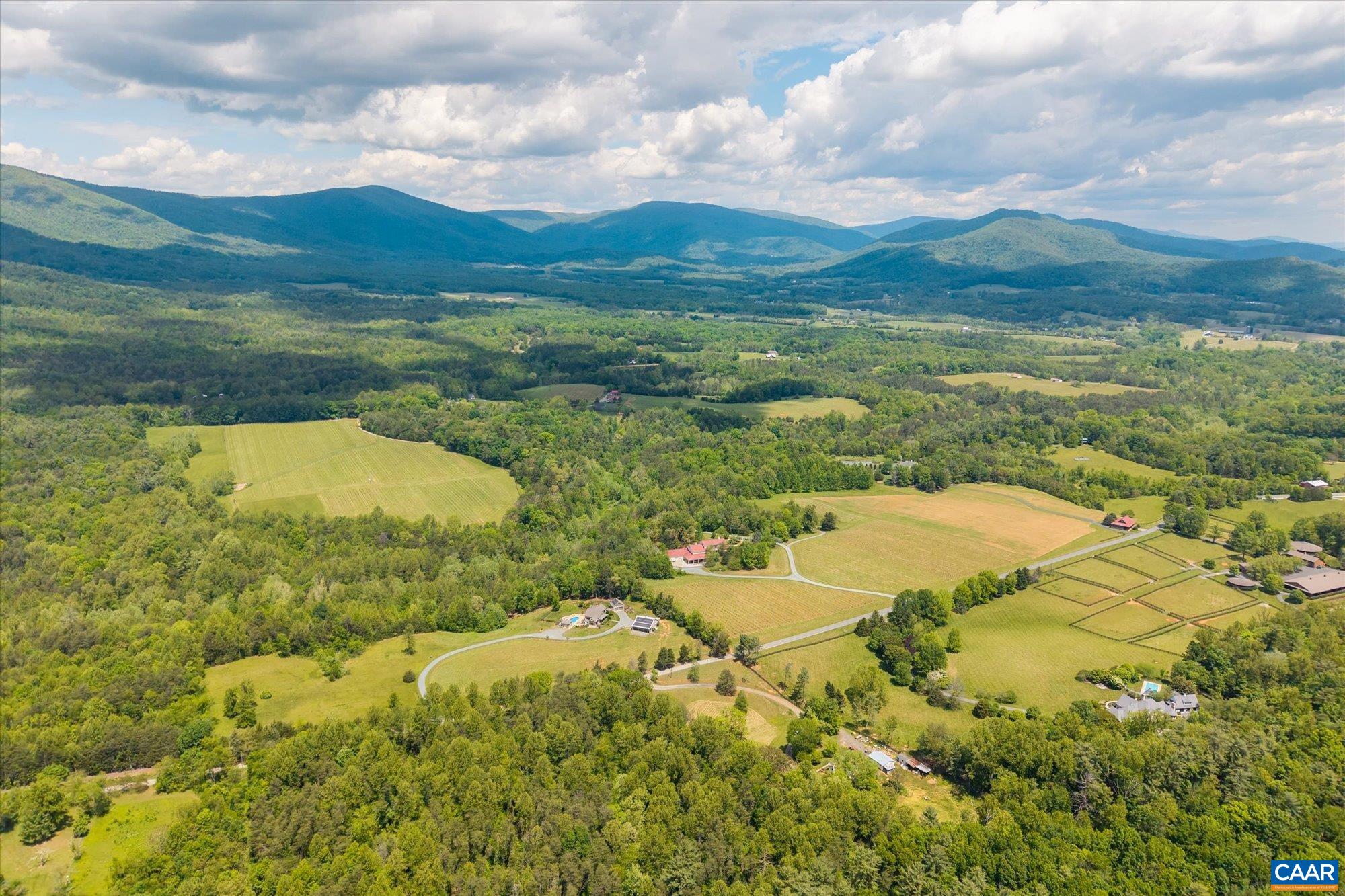 Aerial view of White Hall. Lots of grass and mountains in distance.